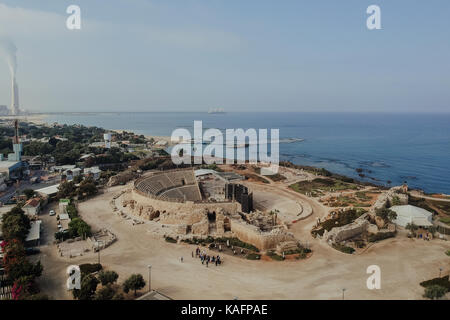 Vista aerea dell'anfiteatro a Cesarea, Israele. Il mare mediterraneo in background. Le canne fumarie di orot rabin la stazione di alimentazione può essere visto sul Foto Stock