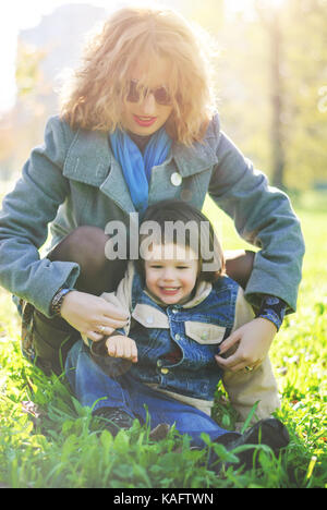 La mamma e il suo giovane figlio giocare nel parco, momenti di autunno Foto Stock