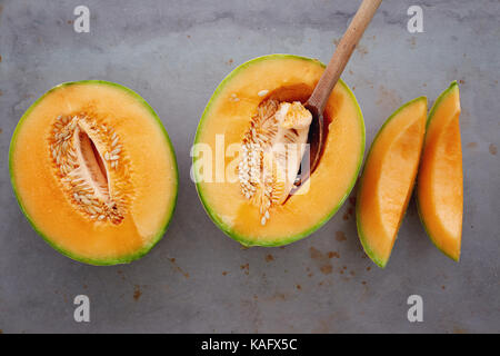 Melone freschi tagliati a pezzetti. tagliata a metà di melone maturo melone al cucchiaio. Foto Stock