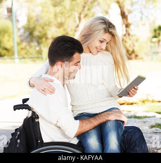 Disabilitato l uomo e la sua fidanzata con tavoletta digitale Foto Stock