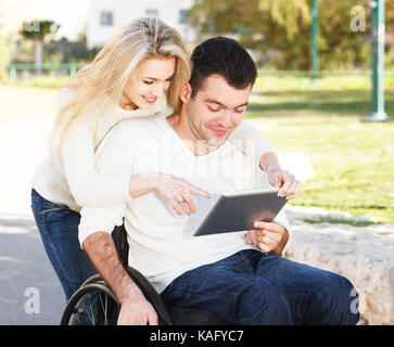 Disabilitato l uomo e la sua fidanzata con tavoletta digitale Foto Stock