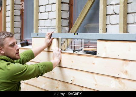 Ripristino di vecchi mattoni casa facciata con nuove tavole di legno Foto Stock