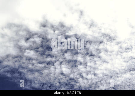 Spindrift nubi si addensano all'inscurimento blu cielo di autunno Foto Stock