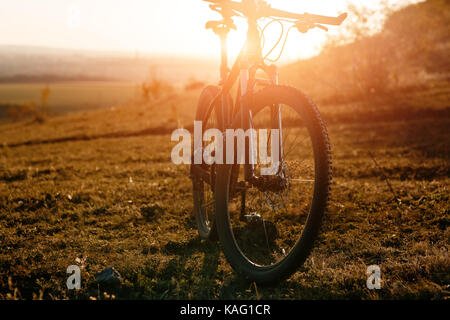 Mountain bike sta solo all'aperto contro autunno paesaggio al tramonto Foto Stock