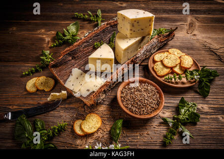 Composizione del formaggio su una corteccia di semi di cumino Foto Stock