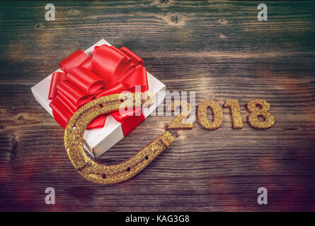 2018 Anno nuovo concetto. numeri d'oro, dono e il ferro di cavallo sullo sfondo di legno Foto Stock