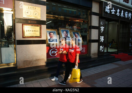 Pechino, Cina - Sep 17, 2017 : le donne nelle camicie rosse a piedi passato le fotografie di mao zedong, Zhou Enlai e liu shaoqi Foto Stock