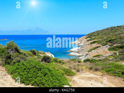 Estate sunshiny stony Sea coast paesaggio con montaggio atthos vista nel lontano(halkidiki, Sithonia, Grecia). Foto Stock