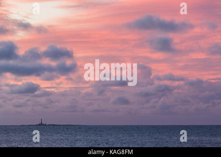 Sunrise con rosa Cielo e nubi ed un faro, faerder fyr, all'orizzonte. faerder national park, verdens ende, vestfold, Norvegia Foto Stock