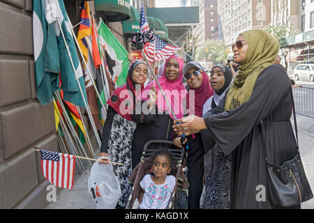 Una famiglia dalla Tanzania prendendo un selfie presso il musulmano parata del giorno in Midtown Manhattan, a New York City. Foto Stock