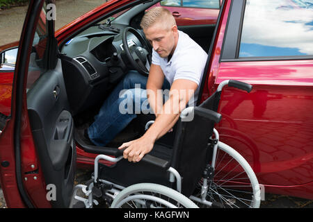 Ritratto di un auto per disabili driver con una sedia a rotelle Foto Stock