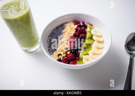 I frullati e una ciotola di yogurt con frutta e semi Foto Stock