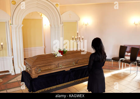 Triste donna con la bara al funerale nella chiesa Foto Stock