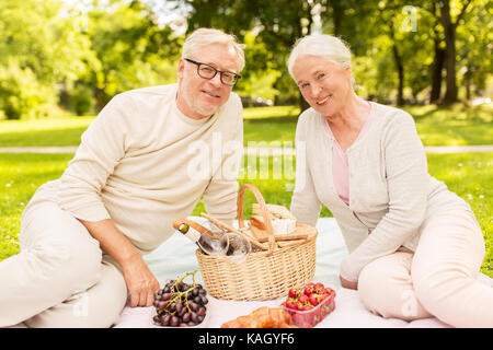 Felice coppia senior avente picnic al parco di estate Foto Stock