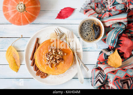 Frittelle di zucca con noci pecan, il miele e la tazza di caffè. autunno composizione alimentare sul tavolo bianco. vista superiore piana e composizione dei laici Foto Stock