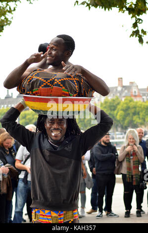 Due ragazzi dal ghana divertente la folla a Londra il south bank Foto Stock