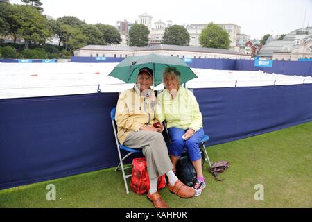 Spettatori riparo dalla pioggia a Eastbourne Tennis Foto Stock