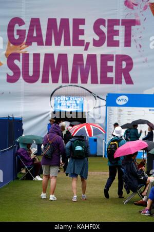 Spettatori riparo dalla pioggia a Eastbourne Tennis Foto Stock