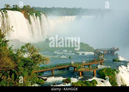 Turisti su una piattaforma di osservazione, cascate Iguazu, Foz do Iguaçu, Parco Nazionale Iguazú, Paraná, Brasile