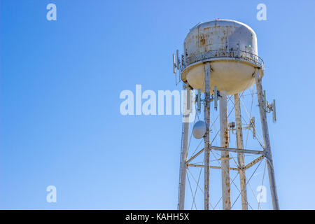 Rusty Water Tower contro il cielo blu sullo sfondo Foto Stock