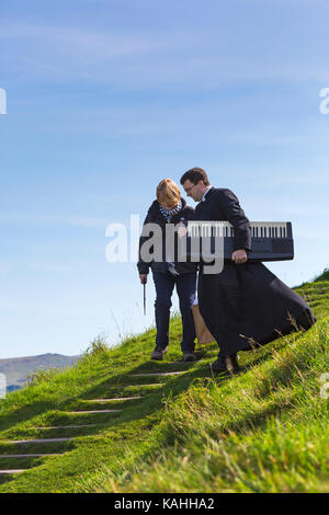 Il reverendo portante organo portatile giù dalla chiesa di San Michele de Rupe, San Michele della roccia, a Brentor, Parco Nazionale di Dartmoor, DEVON REGNO UNITO - Settembre Foto Stock