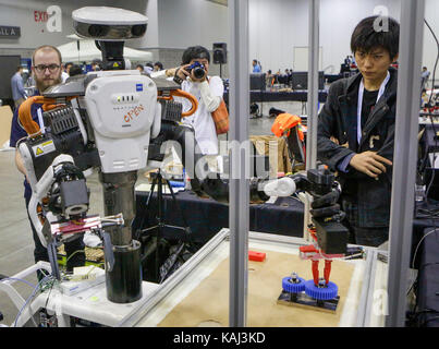 Vancouver, Canada. 26 Sep, 2017. La gente guarda le mani robotiche, la presa e la manipolazione la concorrenza alla XXX Conferenza internazionale sul robot intelligente e sistemi in Vancouver, Canada, sept. 26, 2017. La conferenza di cinque giorni themed "gente cordiale, amichevole robot" ha dato dei calci a fuori il martedì, con 54 aziende mostrando le loro ultime la tecnologia robotica. Credito: liang sen/xinhua/alamy live news Foto Stock