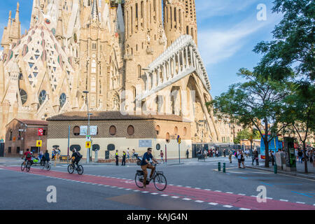 Barcellona, Spagna. Settembre 2017: la gente in bicicletta vicino alla Sagrada Familia chiesa cattolica, opera dell'architetto Antonio Gaudì a Barcellona, in Catalogna. Foto Stock