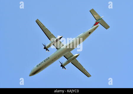 La parte inferiore di un Air Canada piano passeggero come mosche overhead contro un cielo blu. Foto Stock
