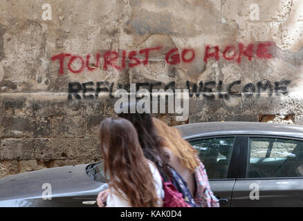 Dipinti murali la lettura "turisti vanno a casa' e abbassare in catalano "abolizione affitto vacanze alloggio" sono illustrati in una via centrale il centro di palma Foto Stock