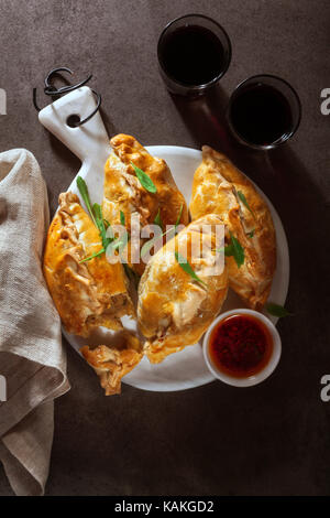 Porro, formaggio e fatti in casa di patate pasties con vino rosso e salsa piccante Foto Stock