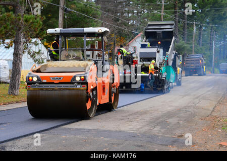 Equipaggio di strada e le attrezzature delle pavimentazioni e laminazione di un village street. Foto Stock