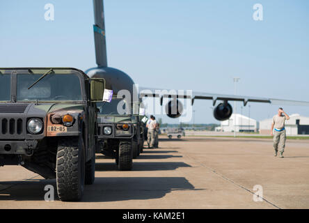 I membri dal 914th disponibilità logistica Squadron e il trentesimo porta antenna squadrone facilitano il caricamento di 10 humvees su un C-17 Globemaster Foto Stock