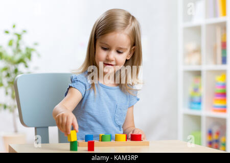 Bambino ragazza ragazzo giocando con selezionatrice giocattoli in vivaio Foto Stock