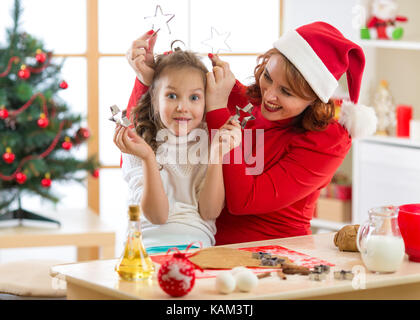 La madre e il bambino figlia rendendo biscotti di Natale e divertirsi. Foto Stock