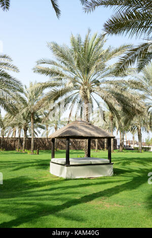 La capanna di relax su un prato verde e il palm tree di ombre in un lussuoso hotel di Dubai, Emirati arabi uniti Foto Stock
