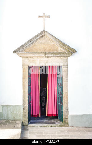 Ingresso della chiesa oltre il muro bianco Foto Stock