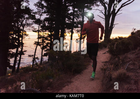Giovane africano indossando un proiettore acceso al crepuscolo Foto Stock