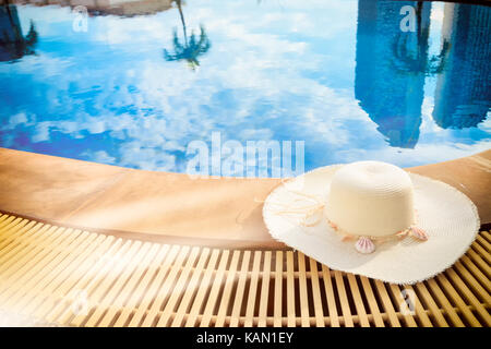 Cappello di paglia da lato della piscina. felice vacanza Foto Stock