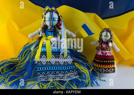 Fatte a mano textill bambola, bambole fatte a mano motanka sullo sfondo della bandiera dell'Ucraina. motanka - folk ucraino doll proteggendo la casa di famiglia Foto Stock