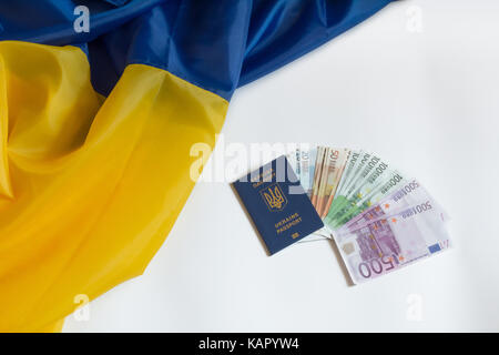 Bandiera dell'Ucraina su uno sfondo bianco, il passaporto di un cittadino di Ucraina e denaro euro Foto Stock