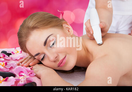 Rilassata giovane donna riceve la microdermoabrasione terapia a beauty spa Foto Stock