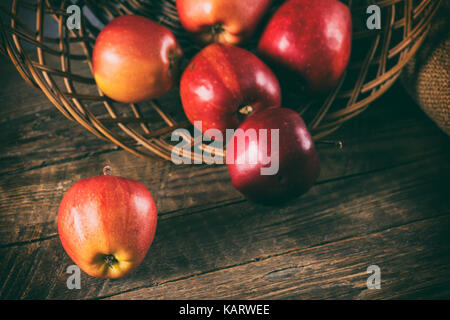 Fresche e mature mele rosse nel cesto di vimini Foto Stock