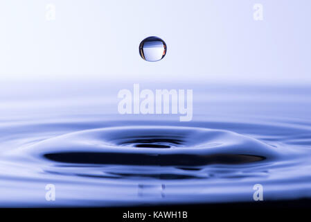 Acqua goccia caduta in acqua facendo a cerchi concentrici Foto Stock