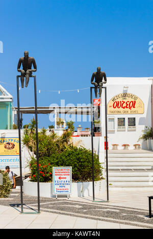 Sculture in bronzo di due uomini seduti sulle barre orizzontali in prossimità del metropolita ortodosso cattedrale di ypapanti in fira villaggio sull'isola di Santorini Foto Stock