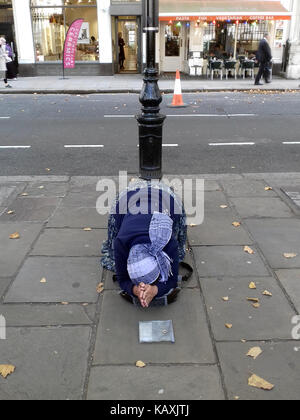 Un mendicante rumeno donna supplica per le monete di ricambio nel centro di Londra, Regno Unito. Foto Stock