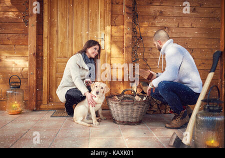 Accoppiare la preparazione di legna da ardere per weekend di casa sulla montagna Foto Stock