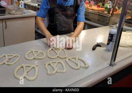 Amish rendendo un pretzel in Reading Terminal Market, Philadelphia, PA, Stati Uniti d'America Foto Stock
