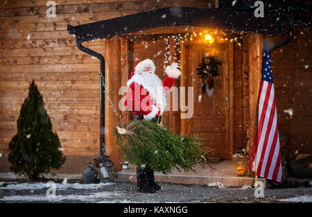 Real santa claus gesticolando ciao anteriore della casa in legno Foto Stock