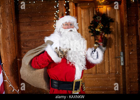 Ritratto di santa claus tenendo la sua borsa e squilla una campana è tempo di Natale Foto Stock