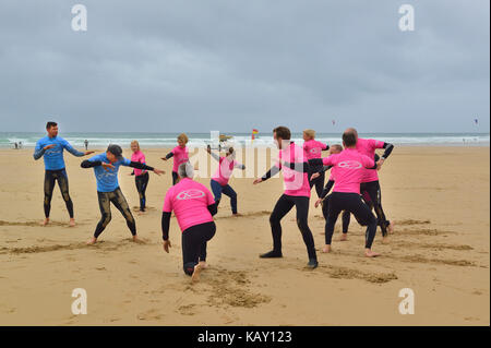 Istruttori di Surf dando lezioni di surf per i partecipanti sulla spiaggia, a Watergate Bay, Newquay Cornwall, England, Regno Unito Foto Stock